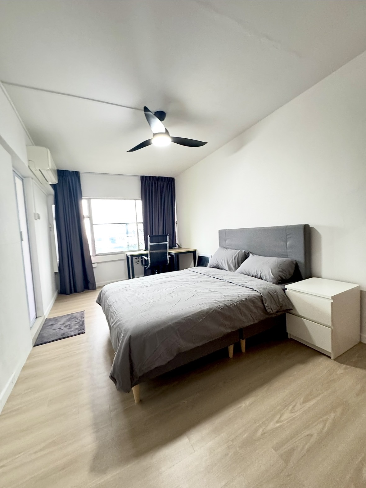 Ventura bedroom with a grey bed, desk by the window, ceiling fan and air conditioning